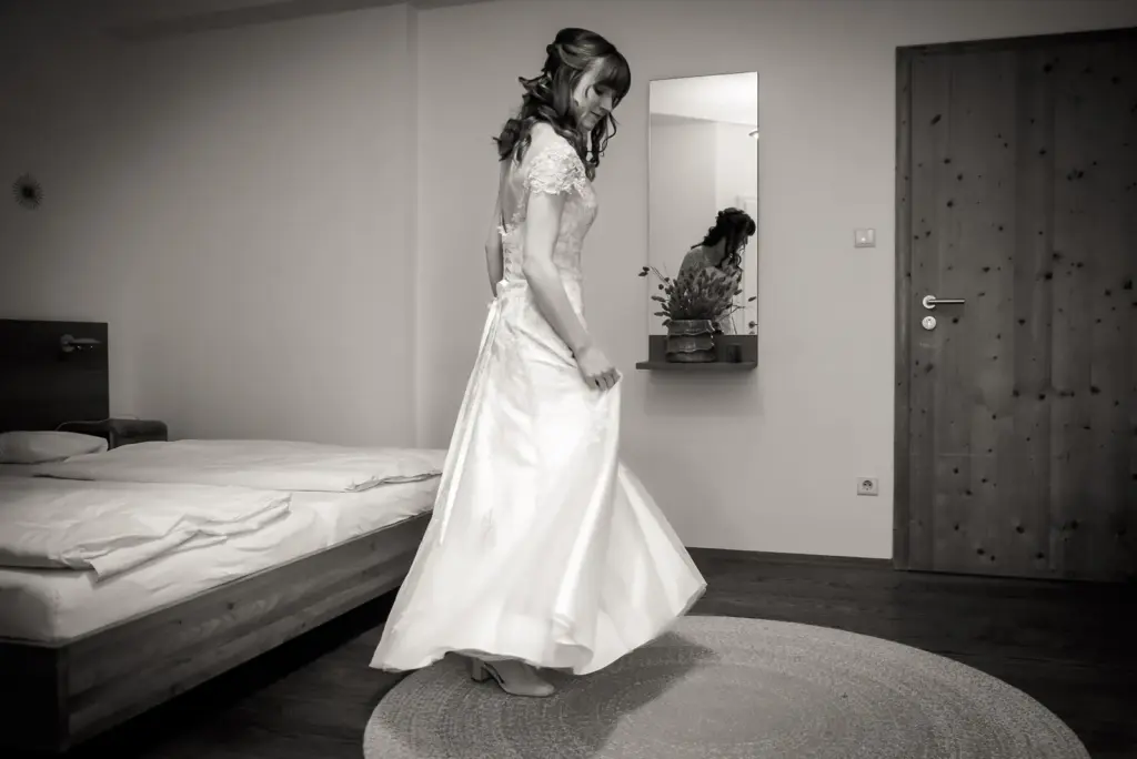 Braut im Hochzeitskleid in einem Zimmer, schwarz-weiß